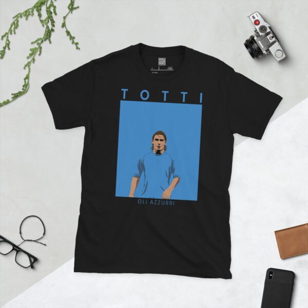 A black T-shirt featuring a modern, stylised graphic of Italian football legend Francesco Totti in a blue national kit. The name "TOTTI" is above the image and "GLI AZZURRI" is below.