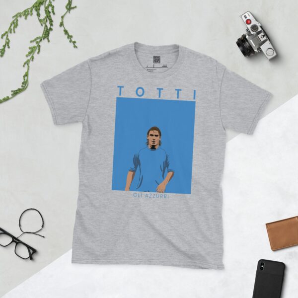 A sports grey T-shirt featuring a unique graphic of Francesco Totti, the Italian World Cup winner. The text "TOTTI" is above his image and "GLI AZZURRI" is below.