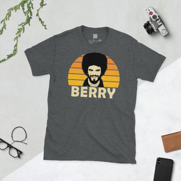 A dark heather T-shirt showing a clean, modern portrait of George Berry, the Molineux icon, with "BERRY" printed in light yellow below the image on a Golden Orange sunburst background.