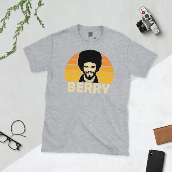 A sports grey T-shirt featuring a unique graphic of Wolves' George Berry. The image is backed by a Golden Orange sunburst and the text "BERRY" is printed in light yellow below the portrait.