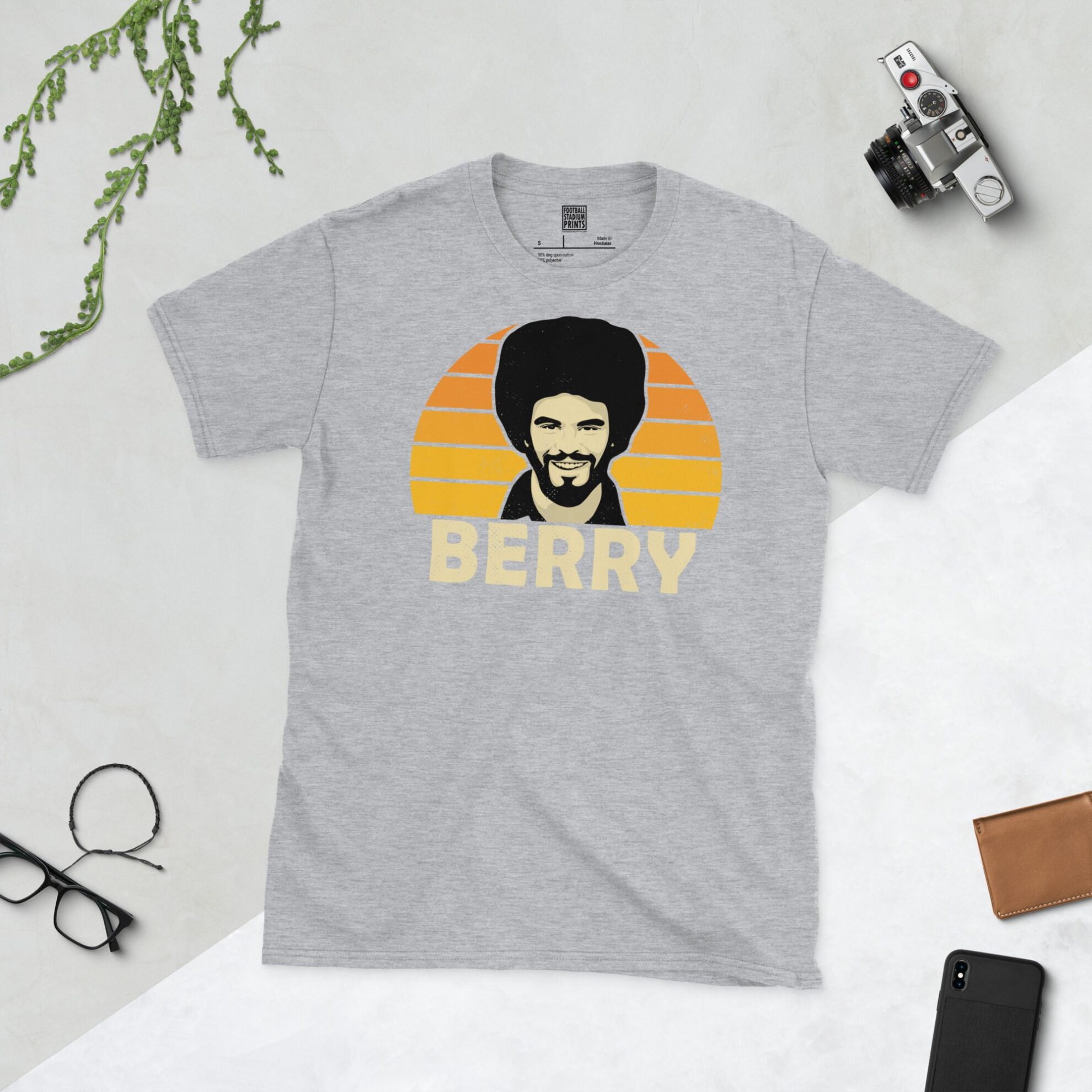 A sports grey T-shirt featuring a unique graphic of Wolves' George Berry. The image is backed by a Golden Orange sunburst and the text "BERRY" is printed in light yellow below the portrait.