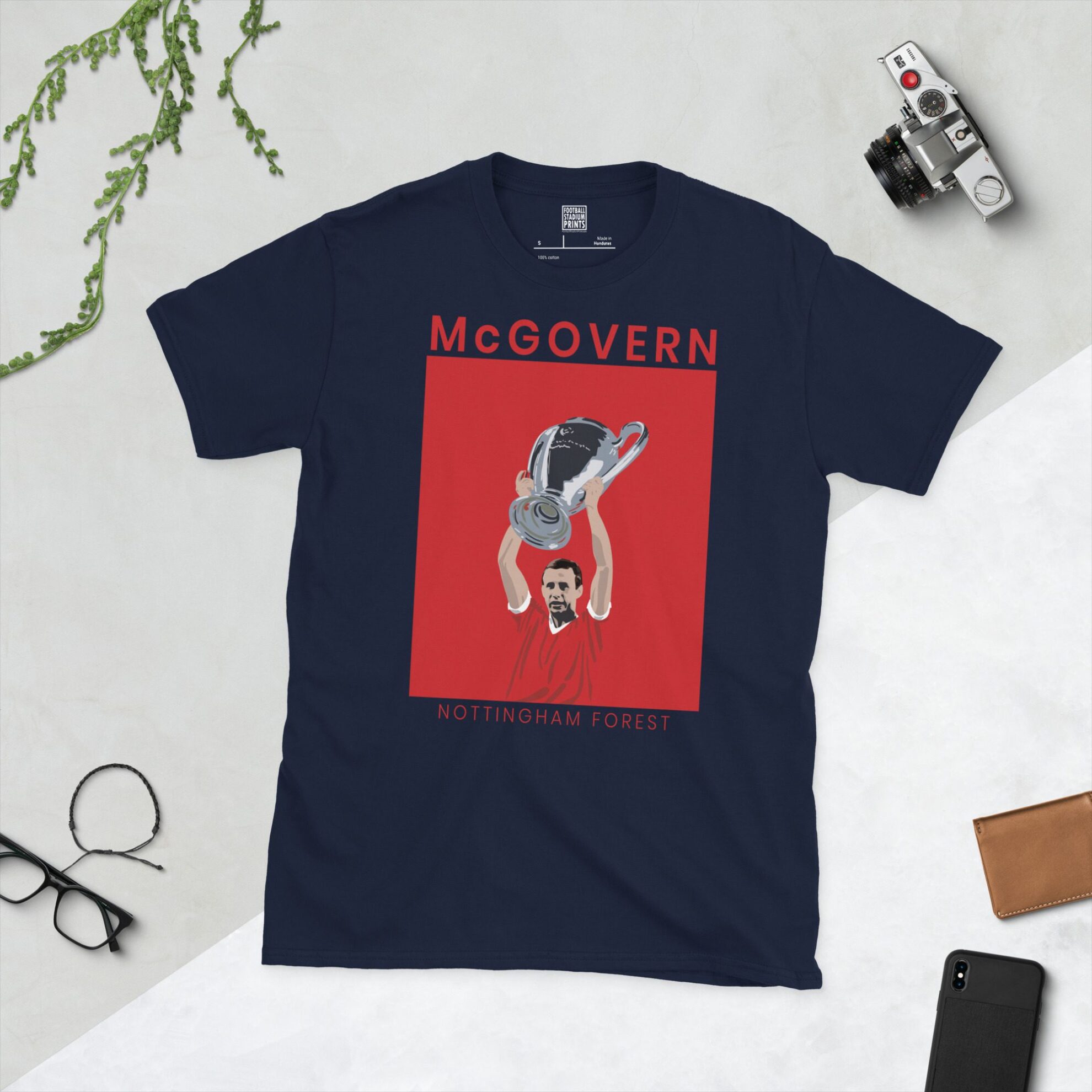 A navy T-shirt displaying a white graphic of John McGovern, the Nottingham Forest European Cup-winning captain. The graphic is backed by a red and white sunburst and the name "MCGOVERN" appears underneath in white.