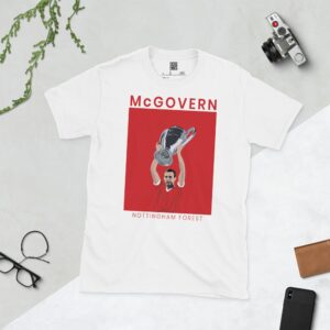 A white T-shirt with a bold, solid black graphic of Nottingham Forest player John McGovern celebrating with the European Cup. The image is set against a red and white background and the name "MCGOVERN" is in black underneath.