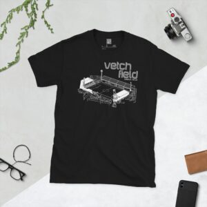 A black T-shirt featuring a white line art graphic of Vetch Field stadium, with "VETCH FIELD" and "SWANSEA, WALES" text above the stadium illustration.