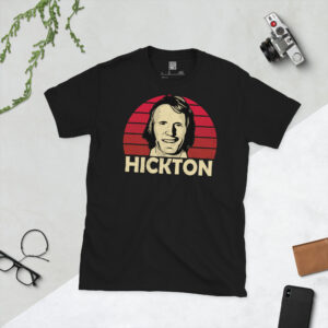 A black T-shirt featuring a stylised, distressed graphic of Middlesbrough legend John Hickton. The portrait is backed by a red striped sunburst, with the name "HICKTON" printed in light yellow below.