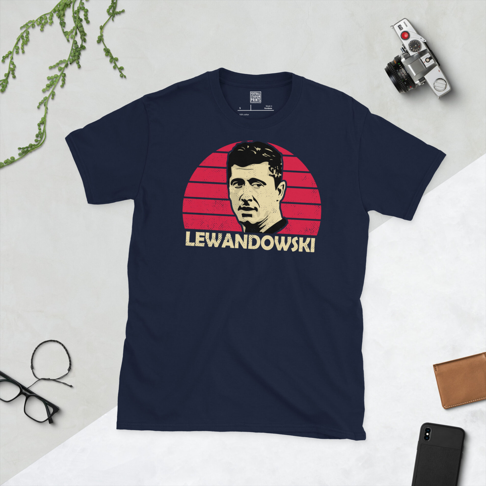 A navy T-shirt displaying an artistic illustration of Robert Lewandowski, the Poland captain. The graphic features a red sunburst and the surname "LEWANDOWSKI" appears underneath in light yellow.