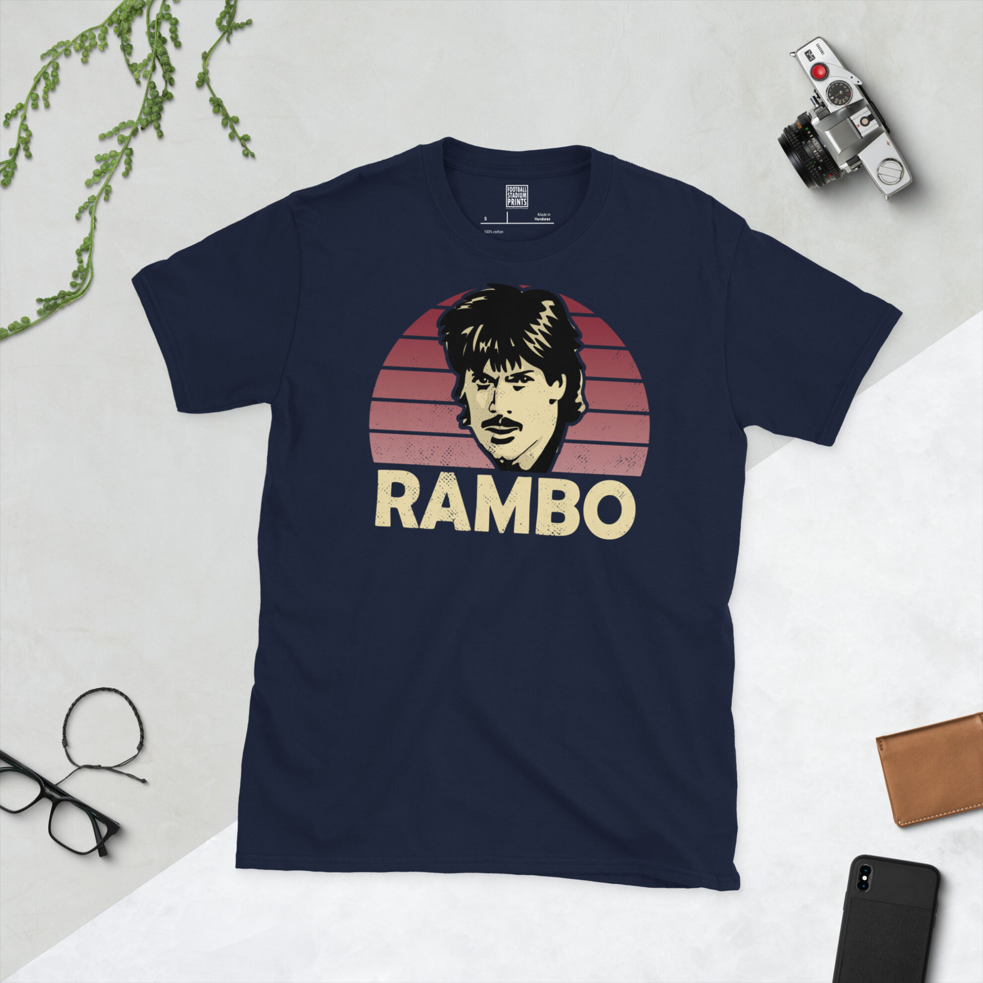 A navy blue T-shirt showcasing a stylised claret-fade illustration of "Rambo" Graham Reed in his iconic Northampton Town kit.