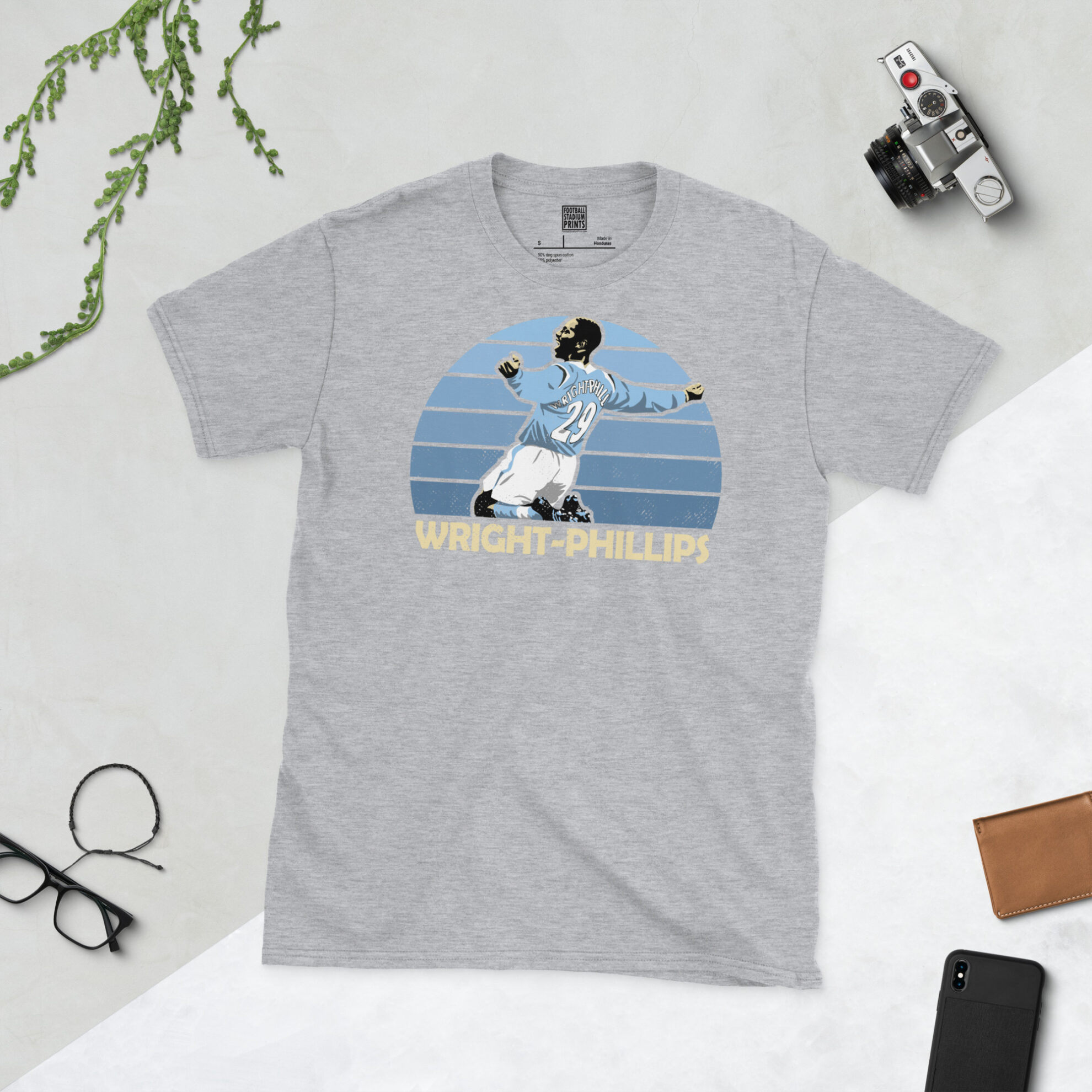 A sports grey T-shirt featuring a bold sky blue sunburst design of Shaun Wright-Phillips, titled with his surname in a classic block font.