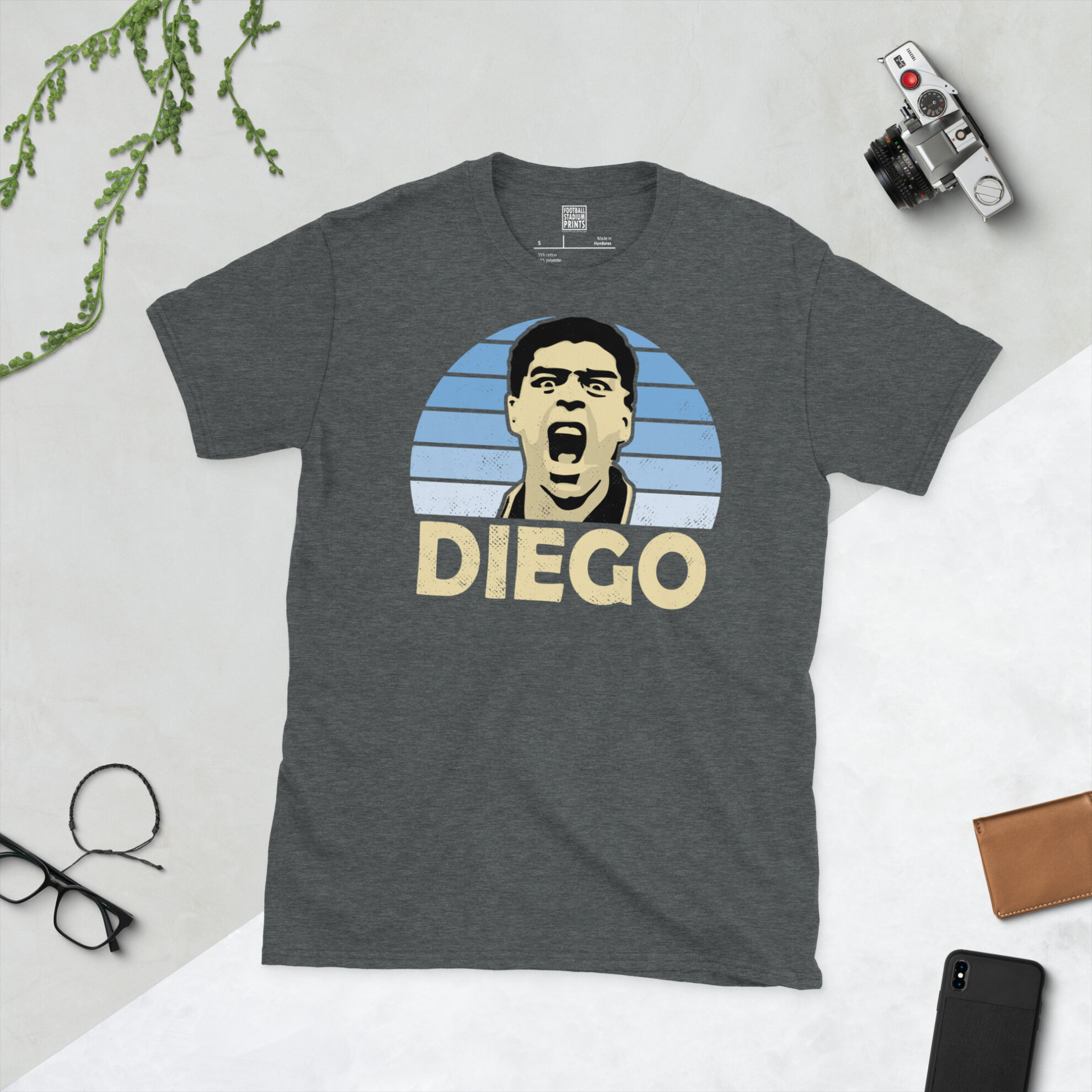 A dark heather grey T-shirt with a vintage-style graphic of Diego Maradona from the 1994 tournament, finished with his name in a classic block font.