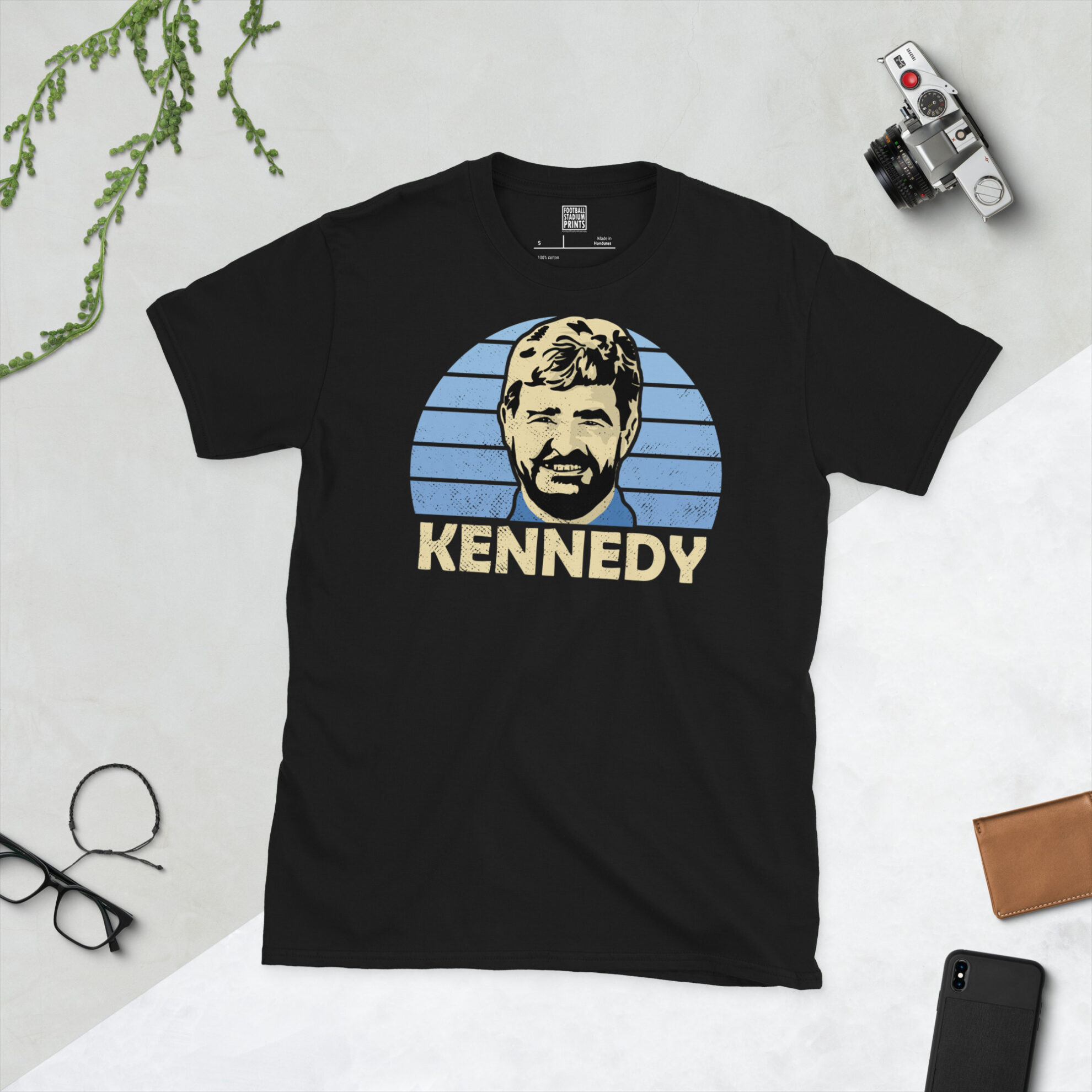A premium black T-shirt featuring a distressed blue sunburst graphic of Forfar Athletic legend Stewart Kennedy with "KENNEDY" in bold lettering.