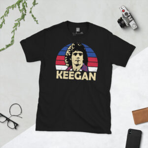 A premium black T-shirt featuring a distressed blue, red and white sunburst graphic of England legend Kevin Keegan with "KEEGAN" in bold lettering.