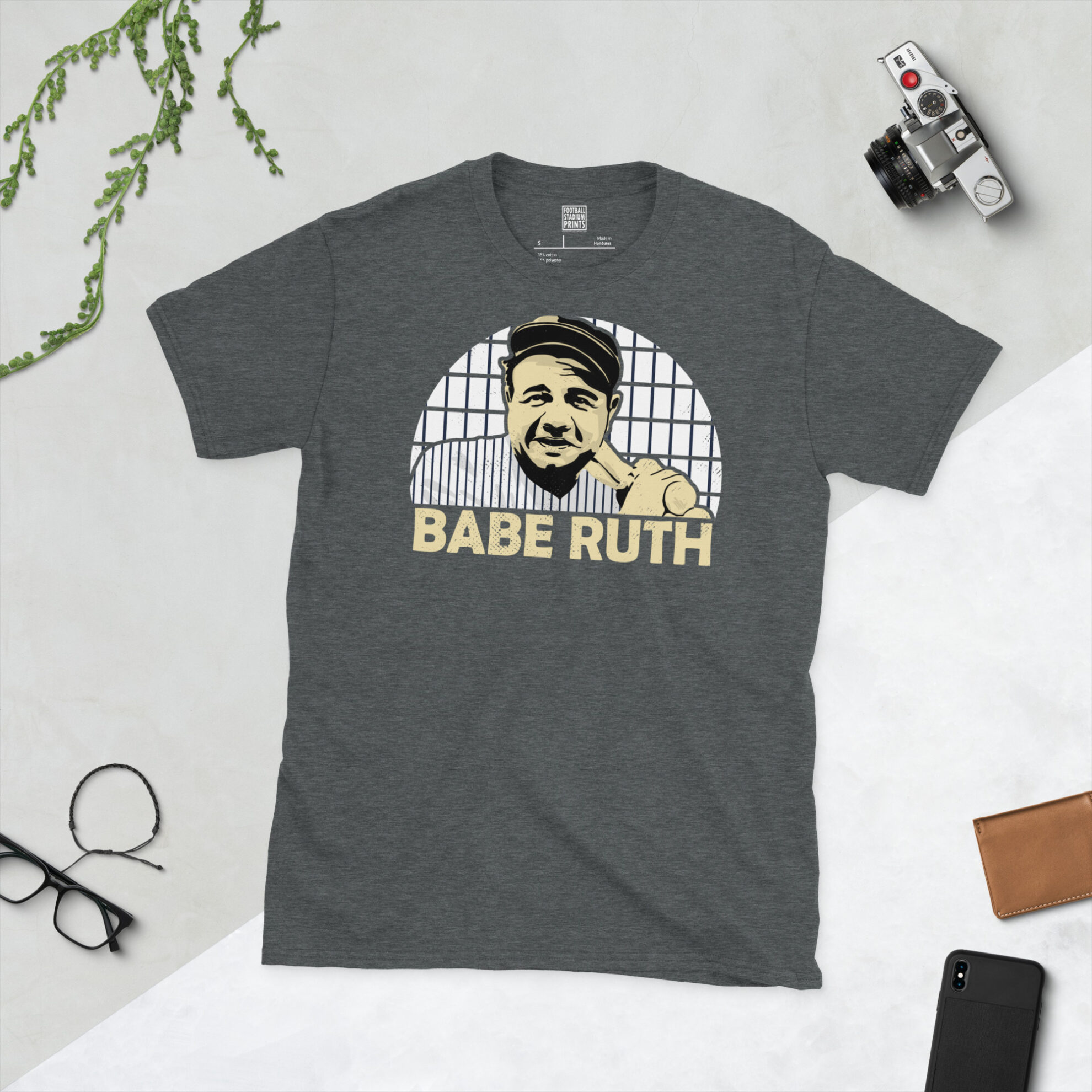 A dark heather grey T-shirt with a vintage-style graphic of Babe Ruth, celebrating his legendary baseball career with the New York Yankees.