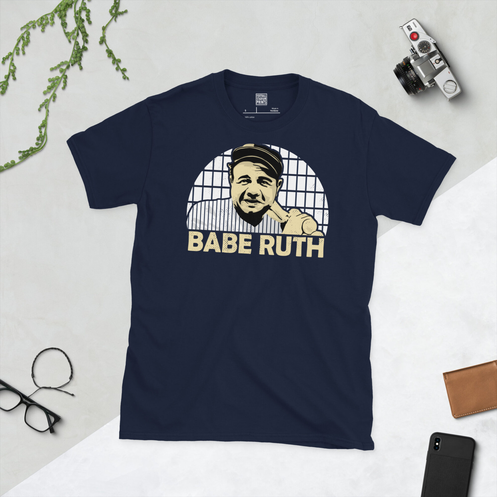 A navy blue T-shirt showcasing a high-contrast illustration of New York Yankees legend Babe Ruth against a classic pinstripe backdrop.