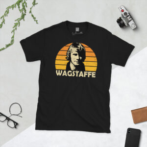 A premium black T-shirt featuring a distressed old gold orange sunburst graphic of Wolves legend Dave Wagstaffe with "WAGSTAFFE" in bold lettering.